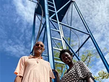 Dos personas junto a la torre azul del depósito de agua en Guinea-Bissau