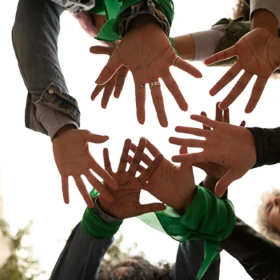 Manos de varias personas unidas formando un círculo