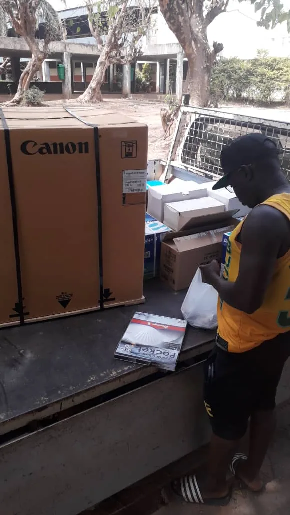 Joven descargando cajas de impresoras Canon desde la caja de un camión