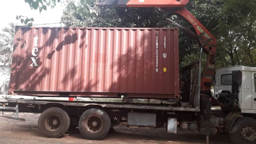Camión grúa transportando el contenedor marítimo hasta el recinto de la facultad