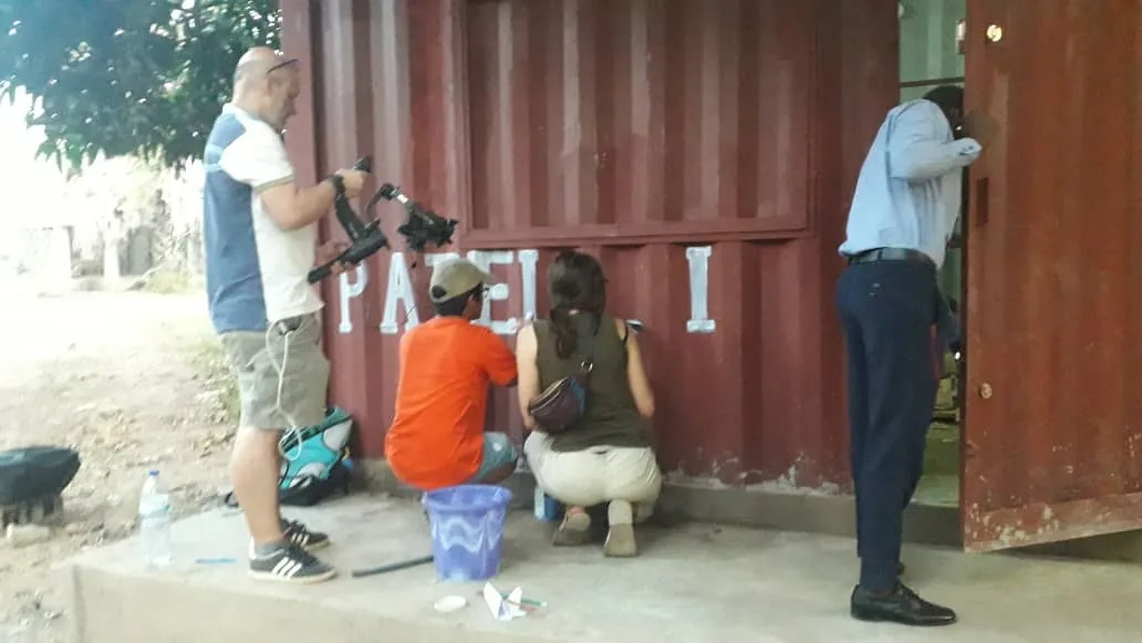 Varias personas dando los acabados al contenedor mientras otra revisa la puerta