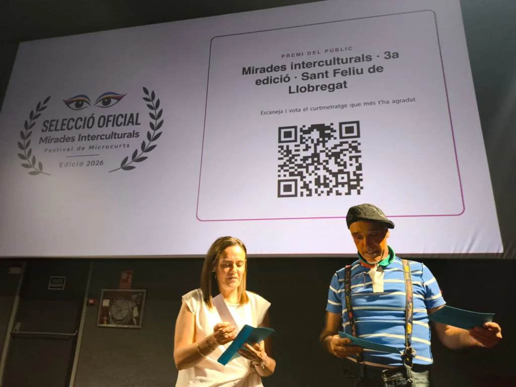 Lectura dels reconeixements a la gala de Mirades Interculturals 2026, amb el codi QR del Premi del Públic a la pantalla
