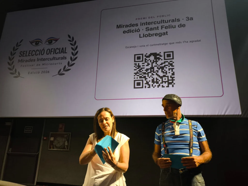 Obertura d'un sobre de reconeixement durant la gala de Mirades Interculturals 2026